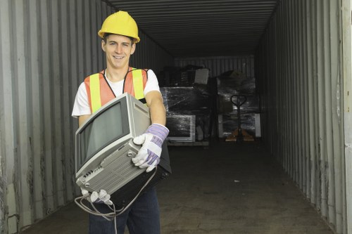 Workers loading furniture for rubbish removal in a Fulham flat